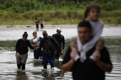 Migrantes que cruzan el río Tuquesa luego de atravesar la selva del Darién en el Darien (Panamá).