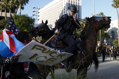 Agentes del Departamento de Policía de Los Ángeles se enfrentan a los manifestantes.