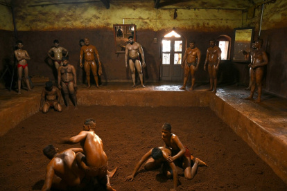 El luchador Mauli Jamdade (C) junto con otros luchadores observan a los juveniles durante una sesión de entrenamiento en Maharashtra, India.
