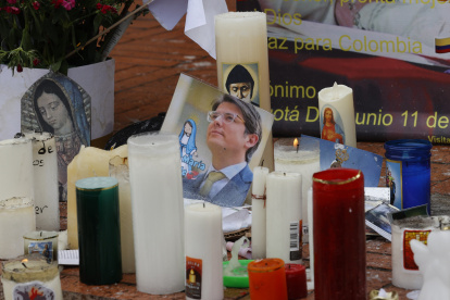 Fotografía de una imagen del senador Miguel Uribe en medio de velas puestas en un altar frente al hospital Fundación Santa Fe de Bogotá