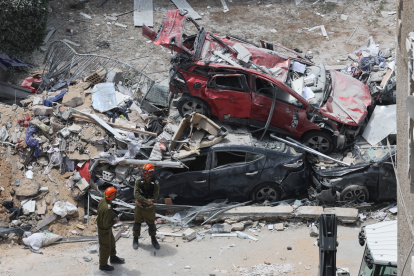 Equipos de rescate en la zona donde impactó en el centro de Israel un misil lanzado por Irán.