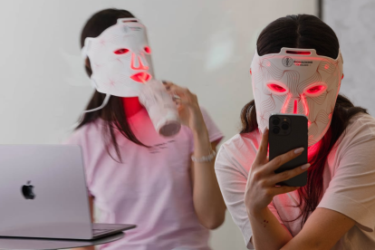 Clientes disfrutan su smoothie con colágeno mientras reciben una terapia de luz LED roja en Sesènroom, el bar de colágeno que es tendencia en Madrid.