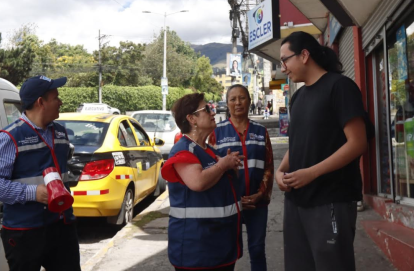 Edgar Vaca, Teresa Sarmiento y detrás Martha Manya, del comité de seguridad de San José de Jarrín Alto de Cotocollao, en el norte de Quito. Informan a vecinos sobre una minga.