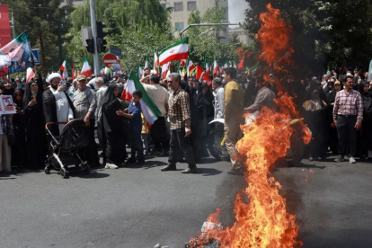 Un grupo de iraníes quema una bandera de EE.UU. en Teherán en protesta por los bombardeos estadounidenses contra instalaciones nucleares de Irán.