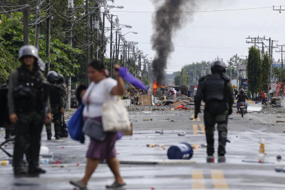 Civiles y policías captados este domingo, 22 de junio de 2025, en una calle bloqueada en Changuinola (Bocas del Toro, Panamá).