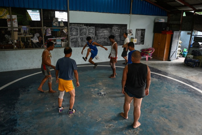 Fotografia de jugadores participando en un partido del tradicional deporte birmano de chinlone en una cancha de Yangon.