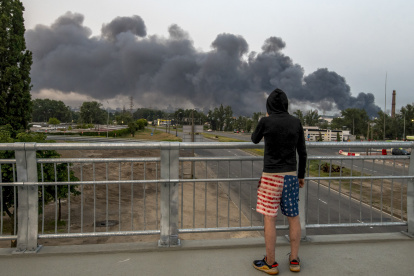 Una persona observa las nubes de humo que se elevan sobre la capital ucraniana tras un ataque nocturno en Kiev, Ucrania, este martes. Al menos dos personas murieron y una docena más resultaron heridas después de que Rusia lanzara un ataque conjunto a gran escala en Ucrania, según el Servicio Estatal de Emergencias.