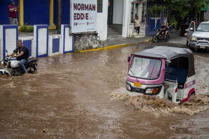 Conductor de moto taxi que circula por una calle inundada, tras el paso del huracán "Erick", enOaxaca (México).