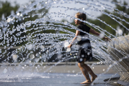 Una niña se refresca en una fuente de agua en Georgetown Waterfront Park en Washington (Estados Unidos).