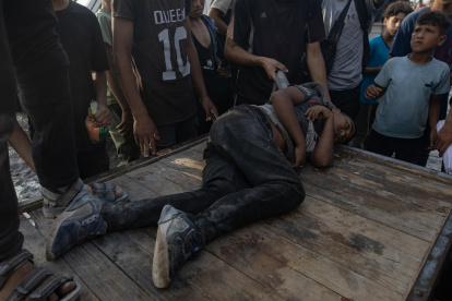 Palestinos ayudan a un herido por el fuego del ejército israelí mientras intentaban recoger paquetes de comida, en la Franja de Gaza.