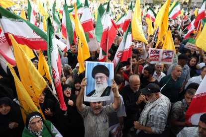 Un iraní sostiene un retrato del líder supremo iraní, el ayatolá Alí Jamenei, entre banderas nacionales de Irán durante una manifestación en Teherán, Irán, el 24 de junio de 2025.