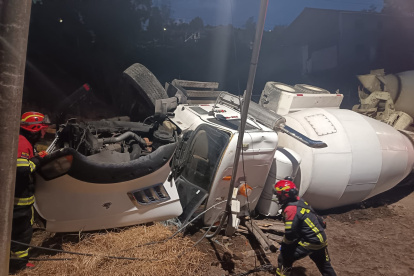 Bomberos Quito verifica volcamiento de vehículo MIXER marca MACK color blanco sobre la vía causando daños en un poste de alumbrado eléctrico.