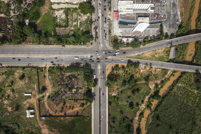 Granjas. Granjas atravesadas por puentes de autopista en Abuja.