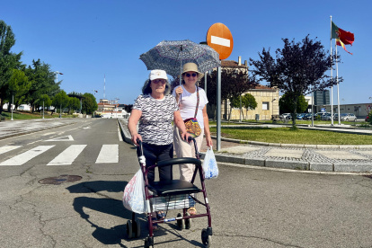 Dos mujeres pasean con el paraguas en la localidad portuguesa de Vilar Formoso (Portugal), para protegerse del sol.