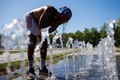 Un peatón en una fuente pública se vierte agua en la cara en un día caluroso en Berlín, Alemania, este miércoles 2 de julio de 2025.