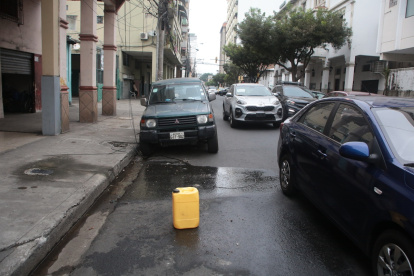 En varias zonas del centro de Guayaquil, los ‘cuidadores’ de carros utilizan envases plásticos para separar los espacios en la vía pública. La actividad sigue sin control.
