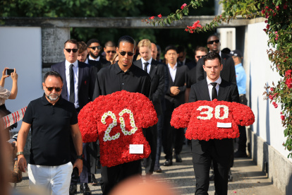 Los jugadores del Liverpool Virgil van Dijk (c) y Andrew Robertson (d) llevan ofrendas florales en el funeral del jugador de fútbol portugués Diogo Jota y su hermano Andre Silva.