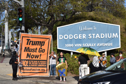 Fotografía de archivo del 20 de junio de 2025 de personas protestando contra las políticas migratorias con una pancarta que dice "Trump debe irse ahora".
