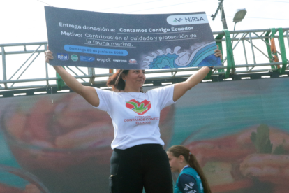 Kerly Briones, presidenta de la Fundación Contamos Contigo Ecuador, sostiene el cheque con la contribución económica a su causa.