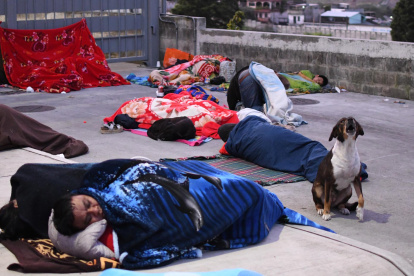 Personas duermen en una calle tras los fuertes temblores el 9 de julio de 2025, en Palín (Guatemala).