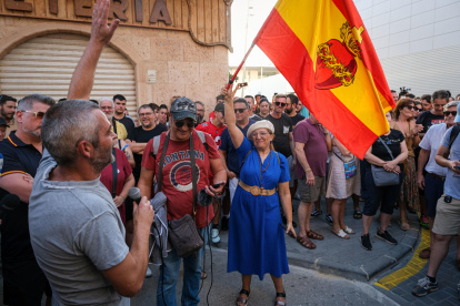Una mujer con una bandera de España con el sagrado corazón de Jesús en la concentración de este 15 de julio de 2025, en Torre Pacheco (Murcia).