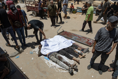 Palestinos lloran sobre los cuerpos de los acribillados.