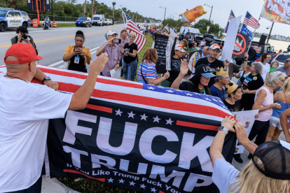 Un ataúd vacío cubierto con la bandera de EE.UU., que simboliza la muerte de la democracia, es llevado por activistas que asisten a la Marcha Crepuscular contra el presidente Donald Trump en Florida, EE. UU.
