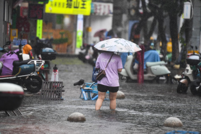 Un peatón camina a través de una zona inundada en Haikou, provincia de Hainan, China, el 20 de julio de 2025.