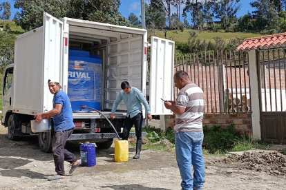 En diversos barrios de Loja, los moradores acuden con baldes y otros recipientes para recolectar agua entregada en camiones.