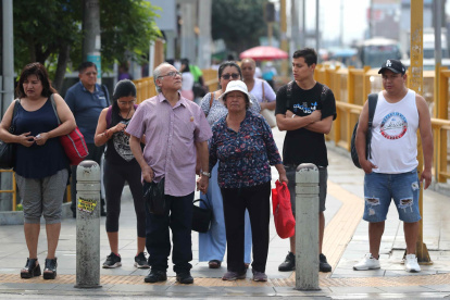 Un grupo de transeúntes al esperar cruzar una calle de Lima (Perú).