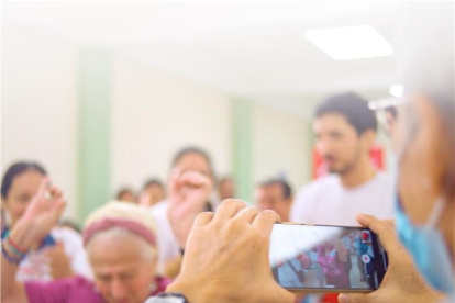 Adultos mayores aprenden a usar la tecnología que tiene un celular.