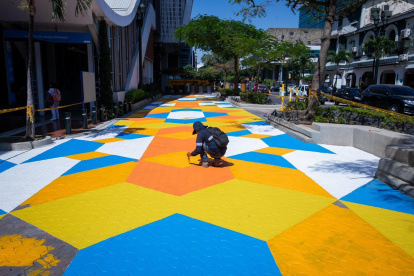 Un obrero pinta un mosaico sobre un tramo de la avenida 9 de Octubre entre Machala y Quito, en el centro de Guayaquil.