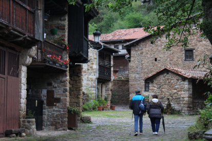 Turismo. Una pareja de visitantes da un paseo por un pintoresco pueblo rural de España para adentrarse en el agroturismo que los atrajo.