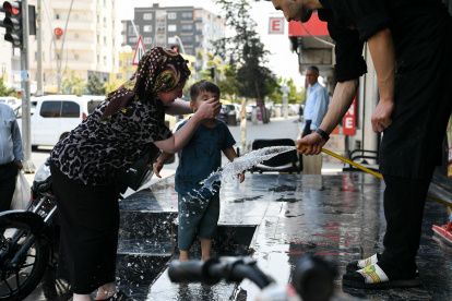 Calor. Las personas pausan su paso para refrescarse con agua en la calle.