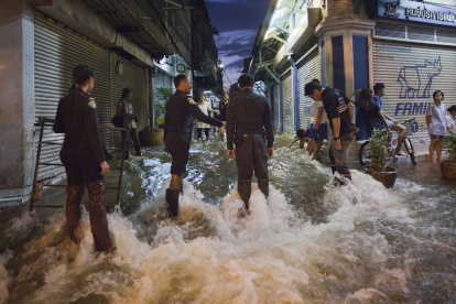 INUNDACIONES EN BANGKOK.
Police officers wait to assist residents passing through flood waters in Bangkok"s Chinatown October 29, 2011. Receding floodwaters north of Bangkok have reduced the threat to the Thai capital, the prime minister said on Saturday, but high tides in the Gulf of Thailand will still test the city"s flood defences. REUTERS/Adrees Latif (THAILAND - Tags: ENVIRONMENT DISASTER TPX IMAGES OF THE DAY)
