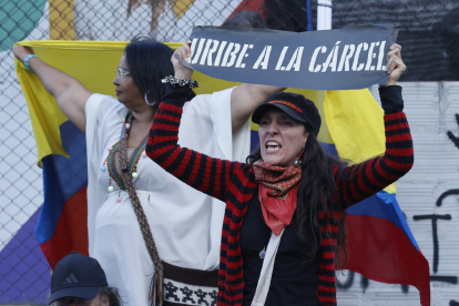 Una detractora del expresidente de Colombia, Álvaro Uribe, sostiene un cartel frente al Complejo Judicial de Paloquemao este lunes, en Bogotá (Colombia). El "juicio del siglo" en Colombia partió en dos la historia judicial del país al imponer en primera instancia una condena a 12 años de prisión y otras sanciones al expresidente Álvaro Uribe (2002-2010), quien consideró "sesgado" el proceso y la sentencia de la jueza Sandra Heredia. EFE/ Mauricio Dueñas Castañeda