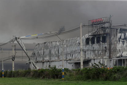 Integrantes del cuerpo de bomberos de Paraguay intentan apagar un incendio este domingo, en el Parque Industrial Logístico Nuestra Señora de la Asunción, en Luque.