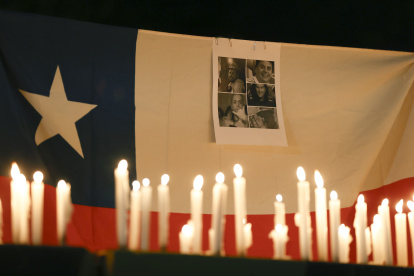 Fotografía de un bandera de Chile con retratos de los mineros atrapados en El Teniente.