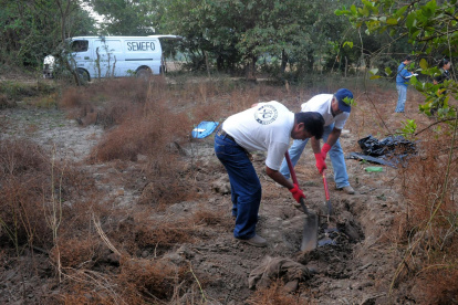 Empleados forenses que desentierran cuerpos de personas halladas en una fosa clandestina en Guanajuato (México).