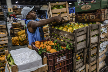 Un hombre transporta frutas en uno de los locales de la Central de Abastecimiento (Ceasa) en Río de Janeiro (Brasil).