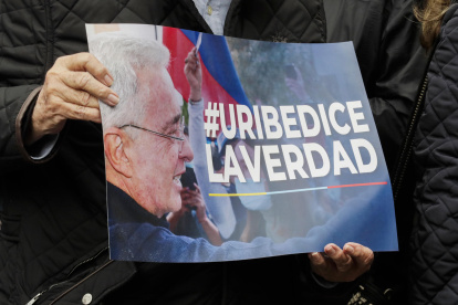 Una persona que sostiene un cartel en apoyo al expresidente colombiano Álvaro Uribe, condenado a doce años de cárcel.