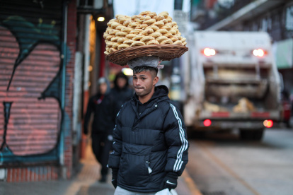 Un hombre vende alimentos que sostiene en su cabeza este jueves 7 de agosto de 2025, en Buenos Aires (Argentina).