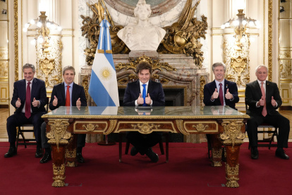 Fotografía cedida por la Presidencia de Argentina de su mandatario, Javier Milei (c), saludando junto a algunos de sus ministros durante una alocución este viernes, en Buenos Aires.