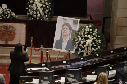Una persona toma una fotografía a una imagen del fallecido senador y precandidato presidencial de Colombia, Miguel Uribe Turbay, este lunes 11 de agosto, en Bogotá.