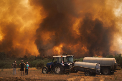 Varios vecinos observan el incendio forestal en Alvite, Moimenta da Beira, Viseu, Portugal.