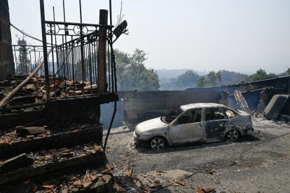 Se observan casas y un automóvil quemados tras un incendio forestal en A Caridade, cerca de Monterrei, en la provincia de Ourense, en el norte de España, el 14 de agosto de 2025.