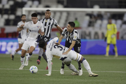 Jefferson Savarino (d) de Botafago disputa el balón con Richard Mina de Liga de Quito en un partido de octavos de final de la Copa Libertadores .