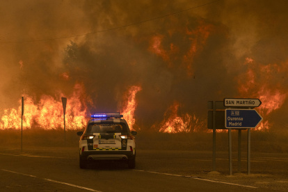 Vecinos y bomberos intentan aplacar el fuego que afecta este viernes a la aldea de Lamas (Cualedro), en Ourense