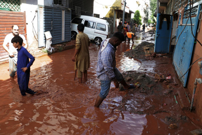 La gente camina entre los escombros de la calle inundada tras varios días de fuertes lluvias en Islamabad, Pakistán, el 6 de agosto de 2025.
