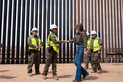 Secretaria de Seguridad Nacional de Estados Unidos, Kristi Noem saludando a un funcionario en frente del muro fronterizo entre Estados Unidos y México.
